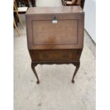 A SMALL WALNUT BUREAU ON CABRIOLE SUPPORTS WITH FALL FRONT AND SINGLE DRAWER