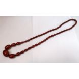 A VINTAGE CHERRY AMBER GRADUATED BEAD NECKLACE, LENGTH 39 CM, WEIGHT 62.3 G, WIDTH OF LARGEST BEAD