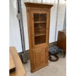 A PINE CORNER CABINET WITH LOWER DOOR AND UPPER GLAZED DOOR