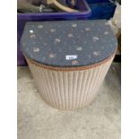 A WICKER LAUNDRY BASKET WITH FABRIC TOP