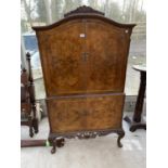 A BURR WALNUT COCKTAIL CABINET ON CABRIOLE SUPPORTS, WITH CARVED DECORATION, TWO LOWER DOORS , TWO