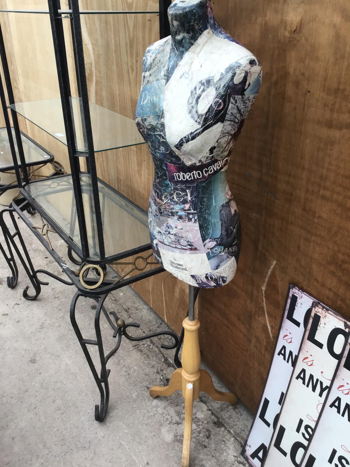 A DECORATED TAILORS DUMMY ON A WOODEN STAND