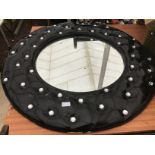 A LARGE BLACK LEATHER EFFECT CIRCULAR MIRROR WITH CRYSTAL STUDS