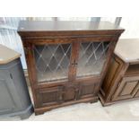 A PRIORY STYLE OAK CABINET WITH TWO LOWER DOORS AND TWO UPPER LEAD GLAZED DOORS