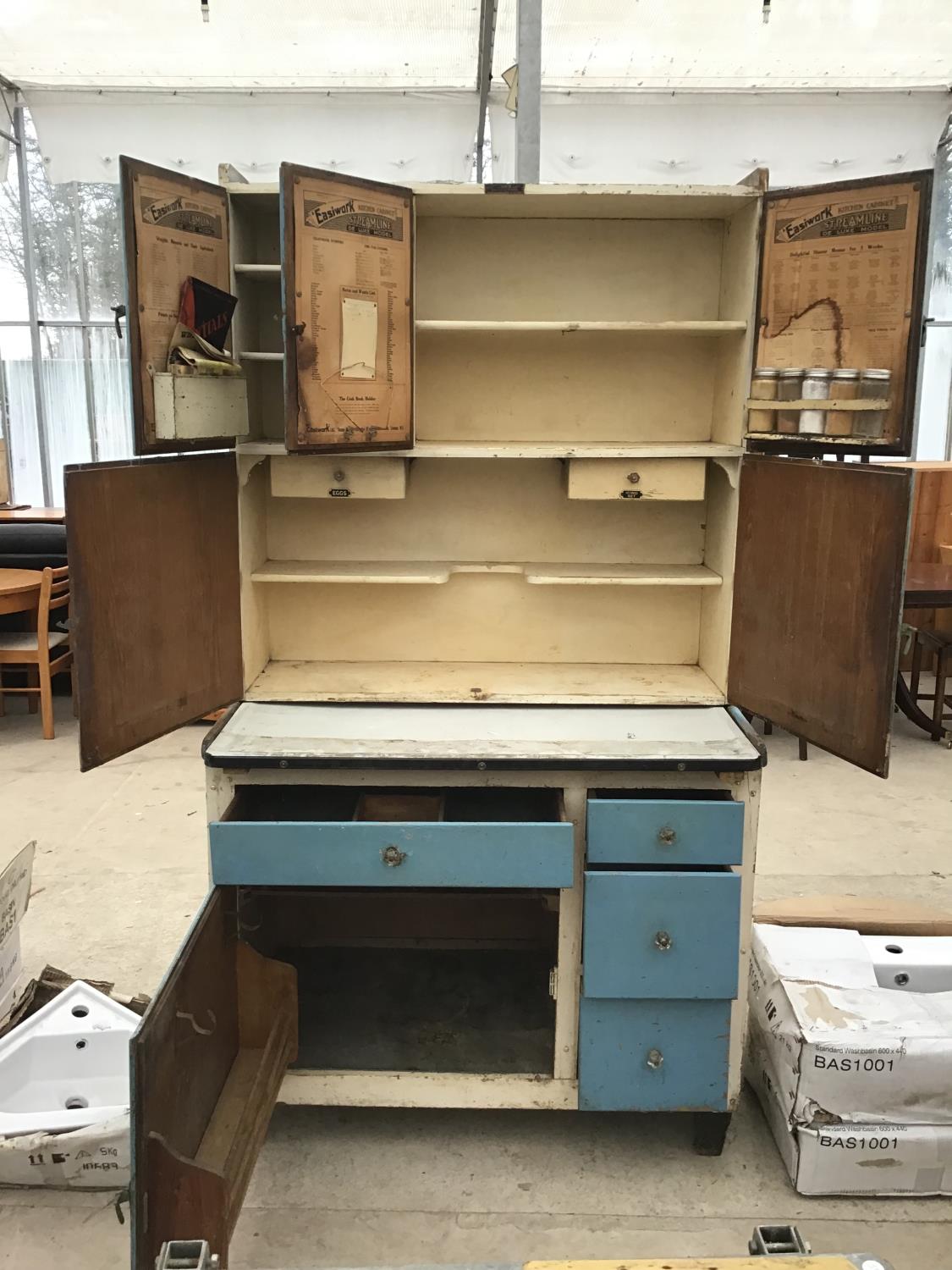 A VINTAGE EASIWORK STREAMLINE DELUXE MODEL KITCHEN CABINET WITH ACCESSORIES TO INCLUDE JARS, EGG