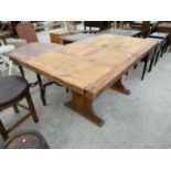 A DISTRESSED PINE DINING TABLE WITH PEGGED STRETCHER RAIL