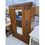 AN OAK WARDROBE WITH CARVED DECORATION, BEVEL EDGE DOOR AND LOWER DRAWER