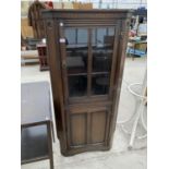 A PRIORY STYLE OAK CORNER CABINET WITH LOWER DOOR AND UPPER GLAZED PANEL DOOR