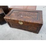 A CARVED CAMPHOR WOOD BEDDING CHEST WITH ORIENTAL DECORATION AND BRASS CLASP