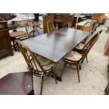 AN ERCOL DRAW LEAF ELM DINING TABLE WITH FOUR ERCOL DINING CHAIRS AND TWO CARVERS
