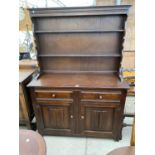 AN OAK DRESSER WITH TWO DOORS, TWO DRAWERS AND UPPER PLATE RACK