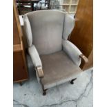 A WING BACK ARMCHAIR ON MAHOGANY CABRIOLE SUPPORTS