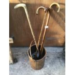 A COPPER BUCKET WITH FOUR WOODEN WALING STICKS