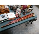 A GROUP OF FOUR VINTAGE WOODEN WALKING STICKS, THREE WITH BRASS HEADS