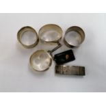 A MIXED GROUP OF HALLMARKED SILVER ITEMS - FOUR NAPKIN RINGS AND A MONEY HOLDER