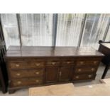 A 19TH CENTURY OAK DRESSER BASE WITH TWO DOORS, TWO SMALL AND SIX LONG DRAWERS (REQUIRES REPAIRS