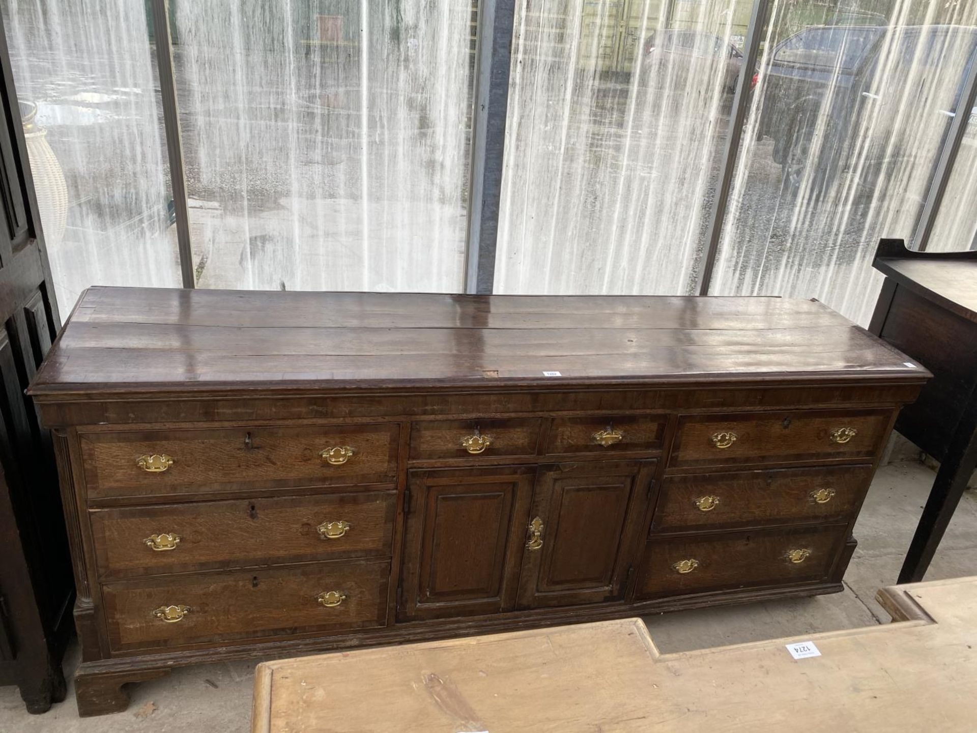 A 19TH CENTURY OAK DRESSER BASE WITH TWO DOORS, TWO SMALL AND SIX LONG DRAWERS (REQUIRES REPAIRS