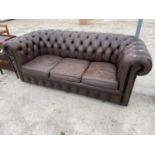 A BROWN LEATHER LOW BUTTON BACK CHESTERFIELD THREE SEATER SOFA