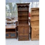 A TALL NARROW OAK DRESSER WITH TWO DOORS, TWO DOORS AND UPPER PLATE RACK