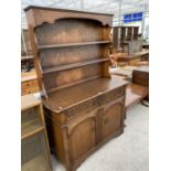 A PRIORY STYLE OAK DRESSER WITH TWO DOORS, TWO DRAWERS AND UPPER PLATE RACK