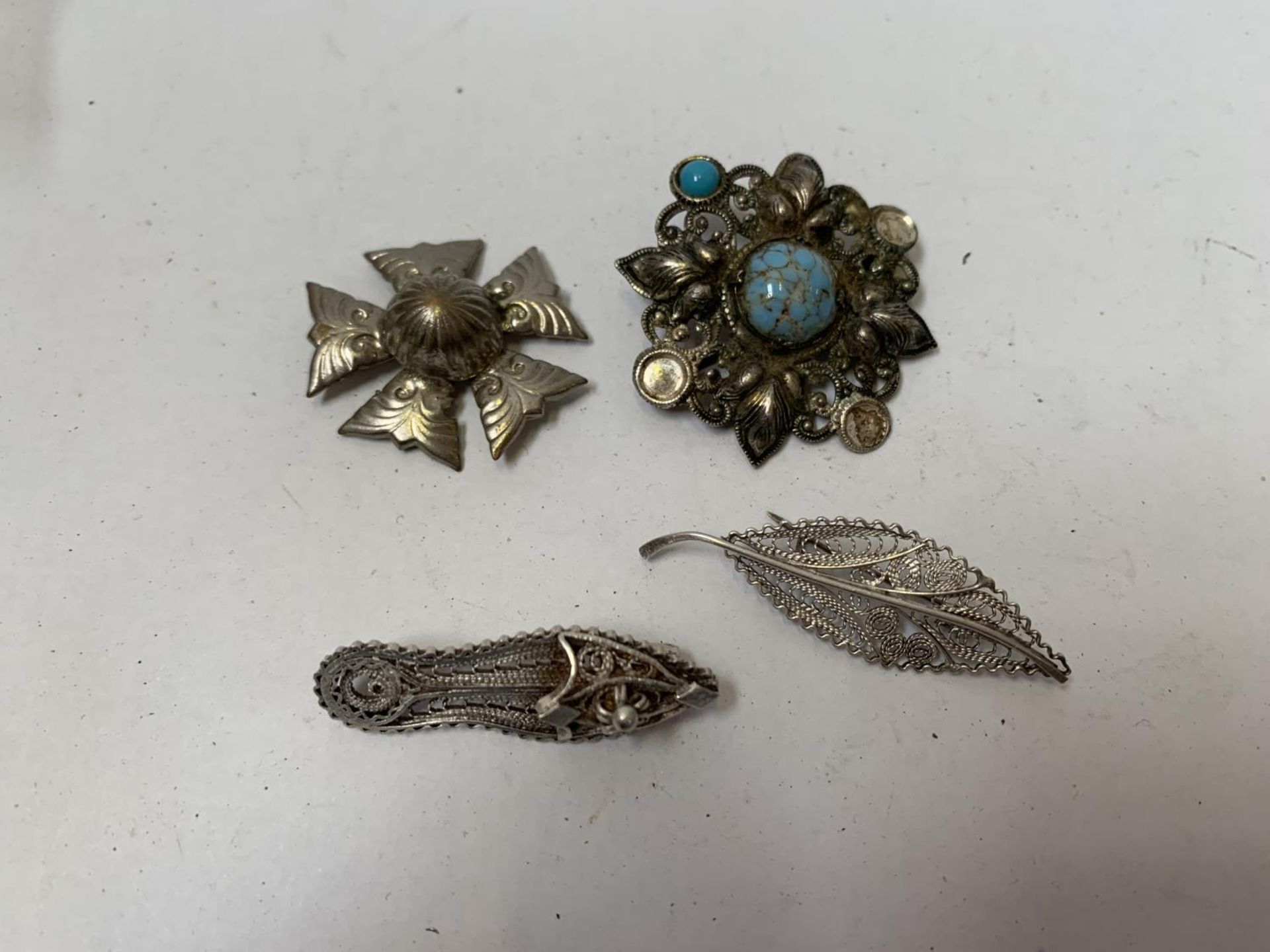A COLLECTION OF FOUR SILVER BROOCHES