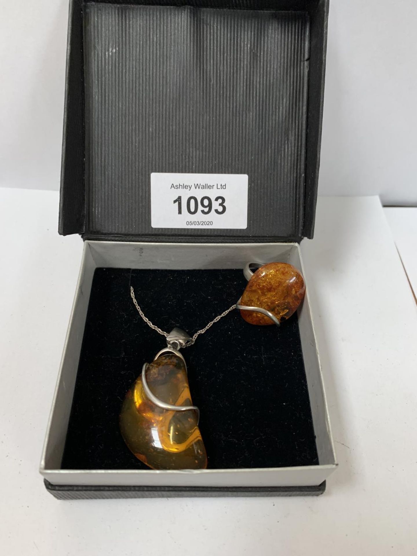 A BOXED SILVER NECKLACE WITH AMBER DESIGN WITH RING