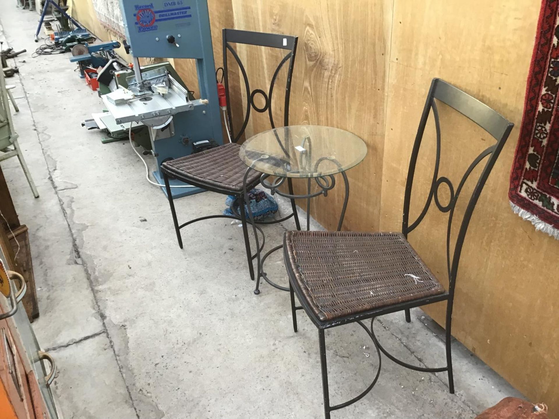 A METAL FRAMED GLASS TOPPED BISTRO STYLE TABLE (45CM) WITH A PAIR OF METAL FRAMED RATTAN SEATED