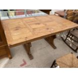 A DISTRESSED PINE DINING TABLE WITH PEGGED STRETCHER RAIL