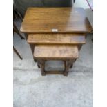 A BELIEVED ERCOL NEST OF THREE OAK TABLES