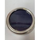 A HALLMARKED SILVER ROUND PHOTO FRAME