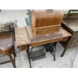 A SINGER ELECTRIC SEWING MACHINE ON A TREADLE BASE