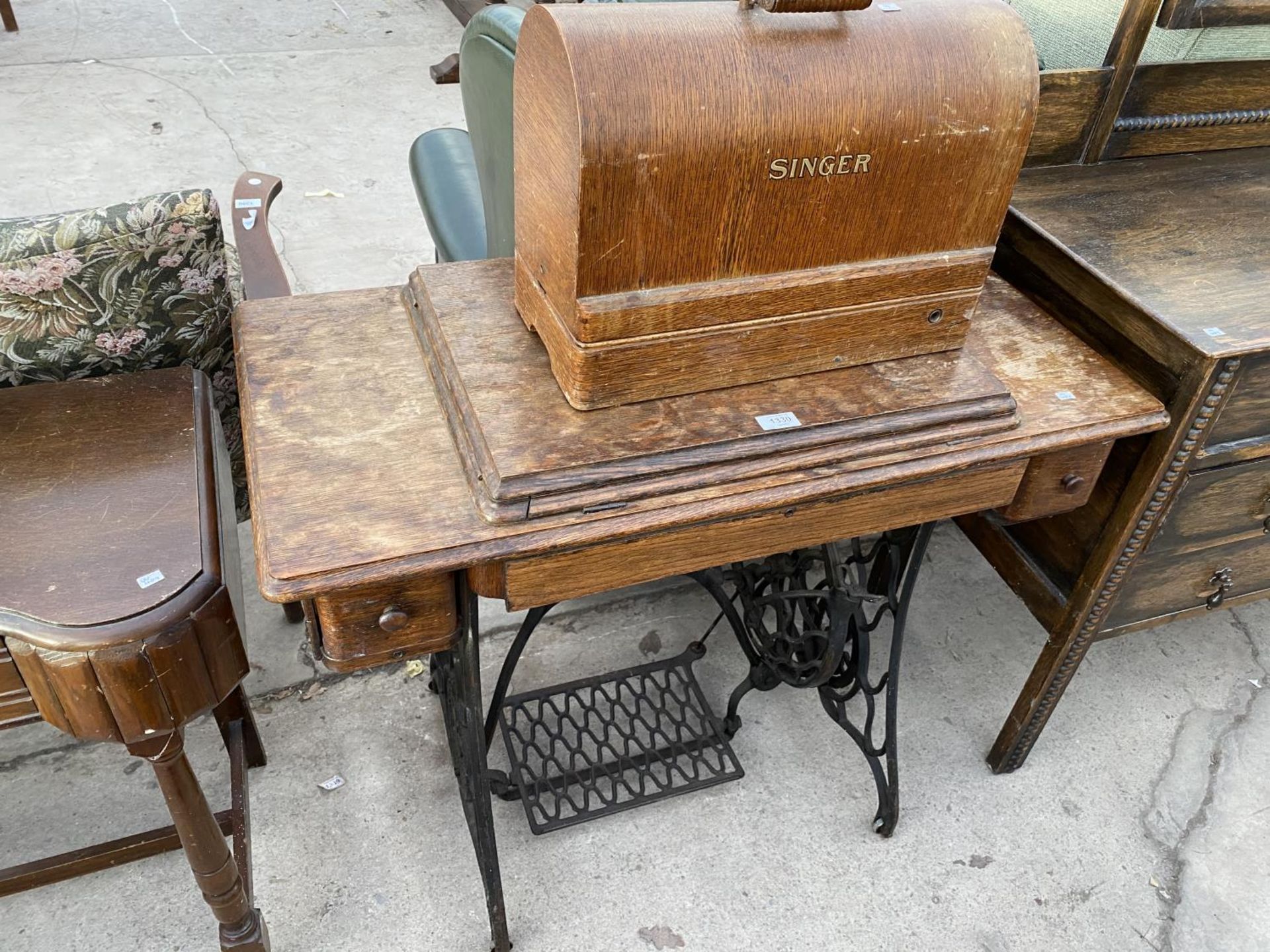 A SINGER ELECTRIC SEWING MACHINE ON A TREADLE BASE