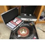 A METAL LOCKABLE CASE WITH KEYS CONTAINING A GOLF KIT, AN AS NEW CASED POKER KIT AND A ROULETTE SET