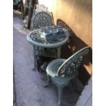 A GREEN PLASTIC ORNATE GARDEN TABLE WITH TWO PLASTIC CHAIRS, TWO SETS OF THREE PLANTERS ON A TRAY