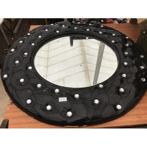 A LARGE BLACK LEATHER EFFECT CIRCULAR MIRROR WITH CRYSTAL STUDS