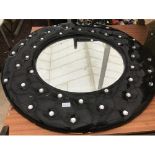 A LARGE BLACK LEATHER EFFECT CIRCULAR MIRROR WITH CRYSTAL STUDS