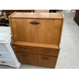 A RETRO TEAK BUREAU WITH FALL FRONT, TWO DOORS AND ONE DRAWER