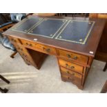 A MAHOGANY TWIN PEDESTAL DESK WITH NINE DRAWERS AND LEATHER WRITING SURFACE