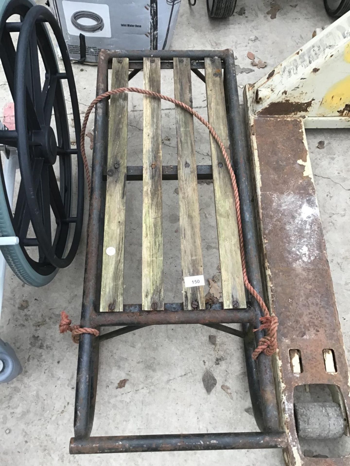 A VINTAGE METAL SLEDGE WITH WOODEN SEAT