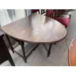 AN OVAL OAK DROP LEAF DINING TABLE ON BARLEY TWIST SUPPORTS