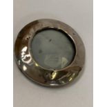 A SMALL ROUND HALLMARKED SILVER PHOTO FRAME