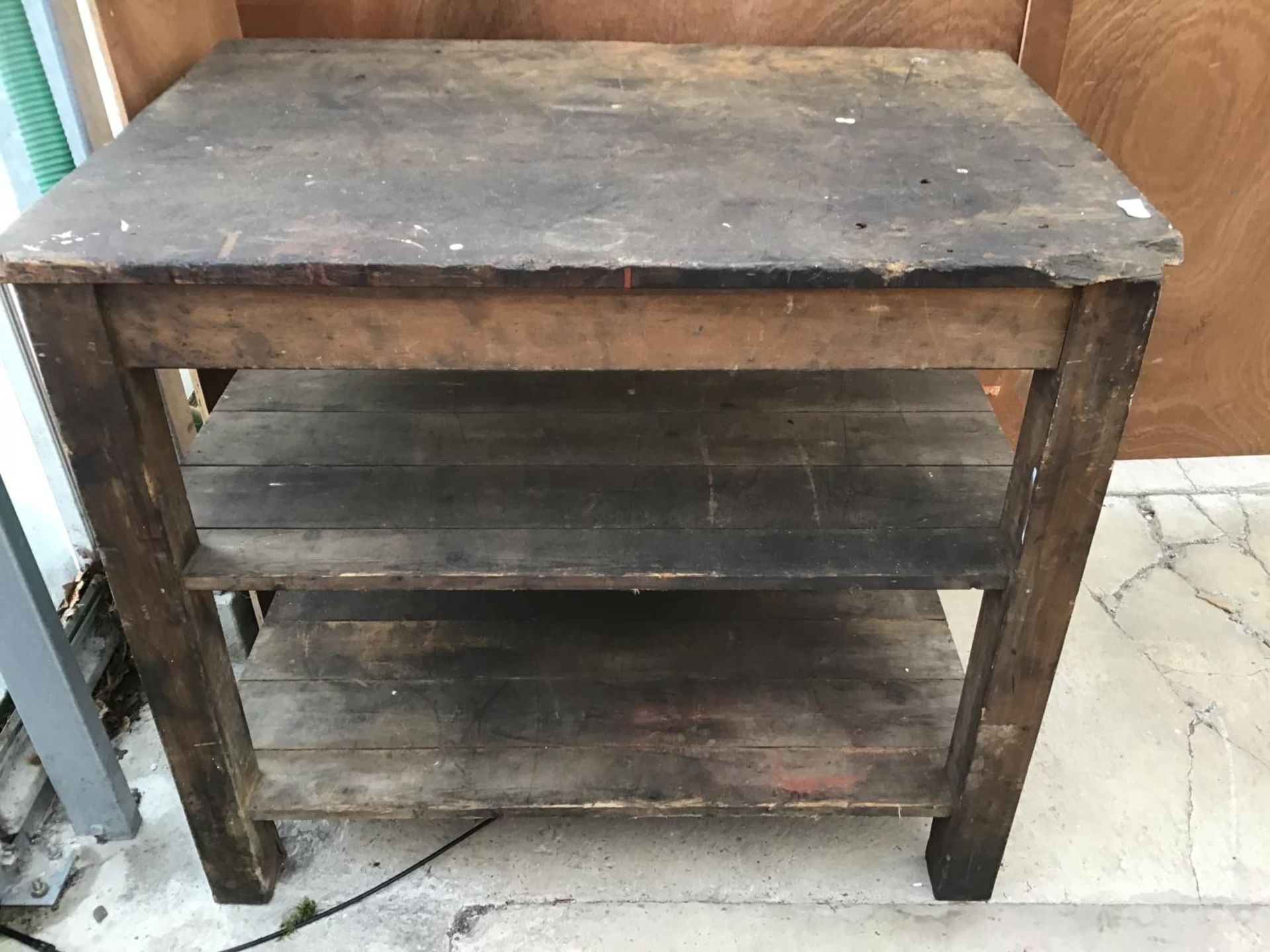 A WOODEN WORK BENCH WITH TWO LOWER SHELVES