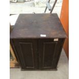 A SMALL WOODEN TWO DOOR CABINET