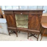 A CARVED MAHOGANY CABINET WITH THREE DRAWERS, TWO SOLID DOORS AND A GLAZED PANEL DOOR