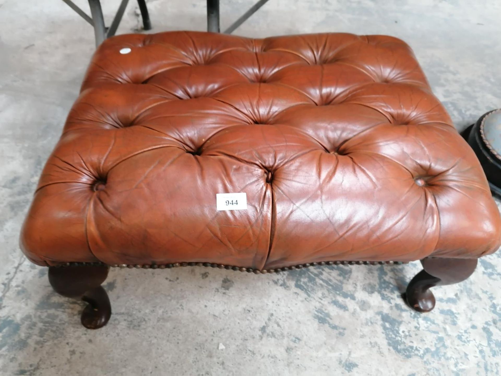 A BROWN CHESTERFIELD LEATHER BUTTON FOOT STOOL