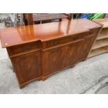 A YEW WOOD BREAK FRONT SIDEBOARD WITH FOUR DOORS AND THREE DRAWERS