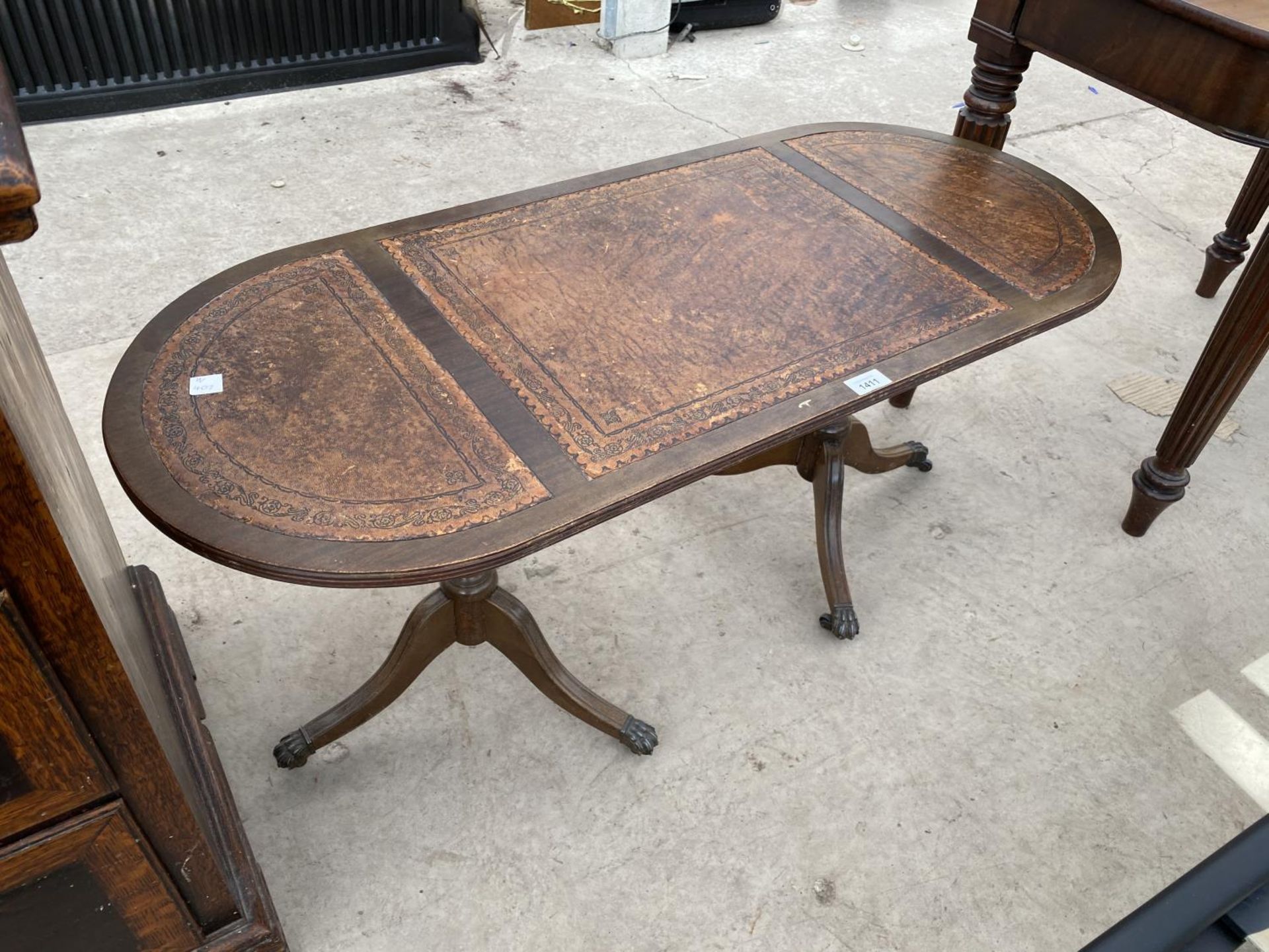 A MAHOGANY COFFEE TABLE ON TWIN PEDESTAL SUPPORTS WITH LEATHER TOP