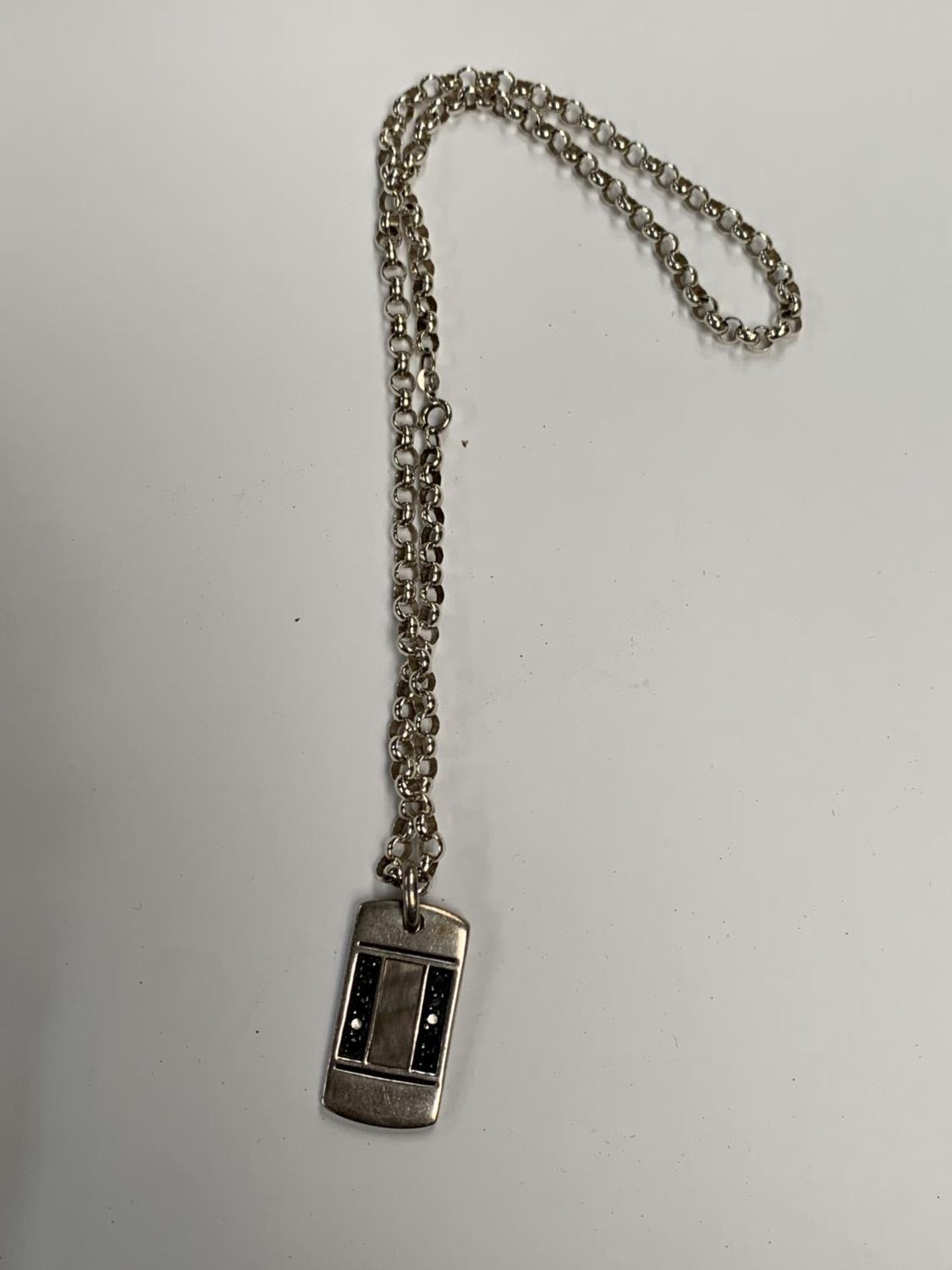 A SILVER CHAIN WITH SILVER PENDANT
