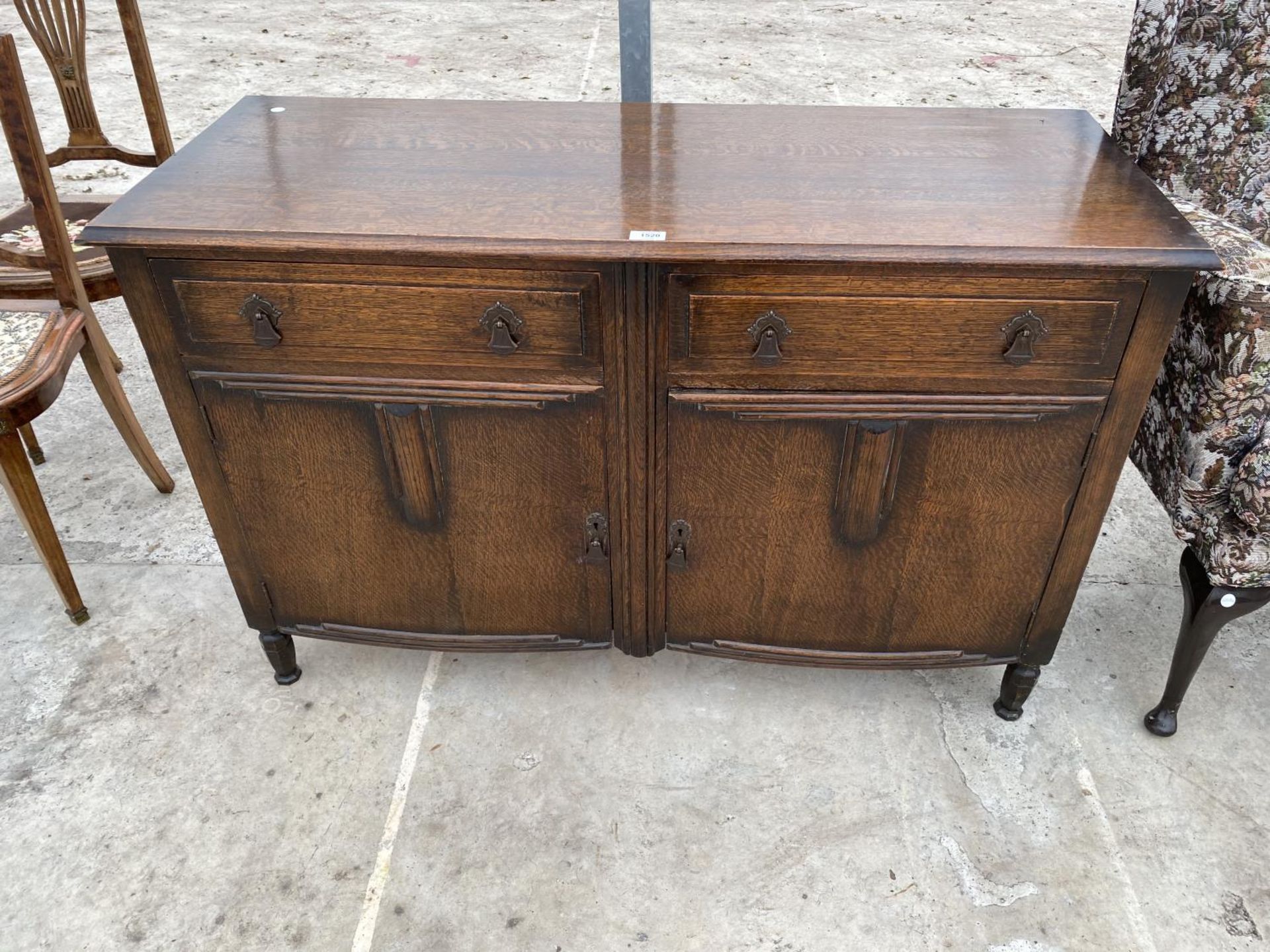 AN OAK SIDEBOARD WITH TWO DOORS AND TWO DRAWERS