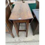 AN OVAL OAK DROP LEAF DINING TABLE